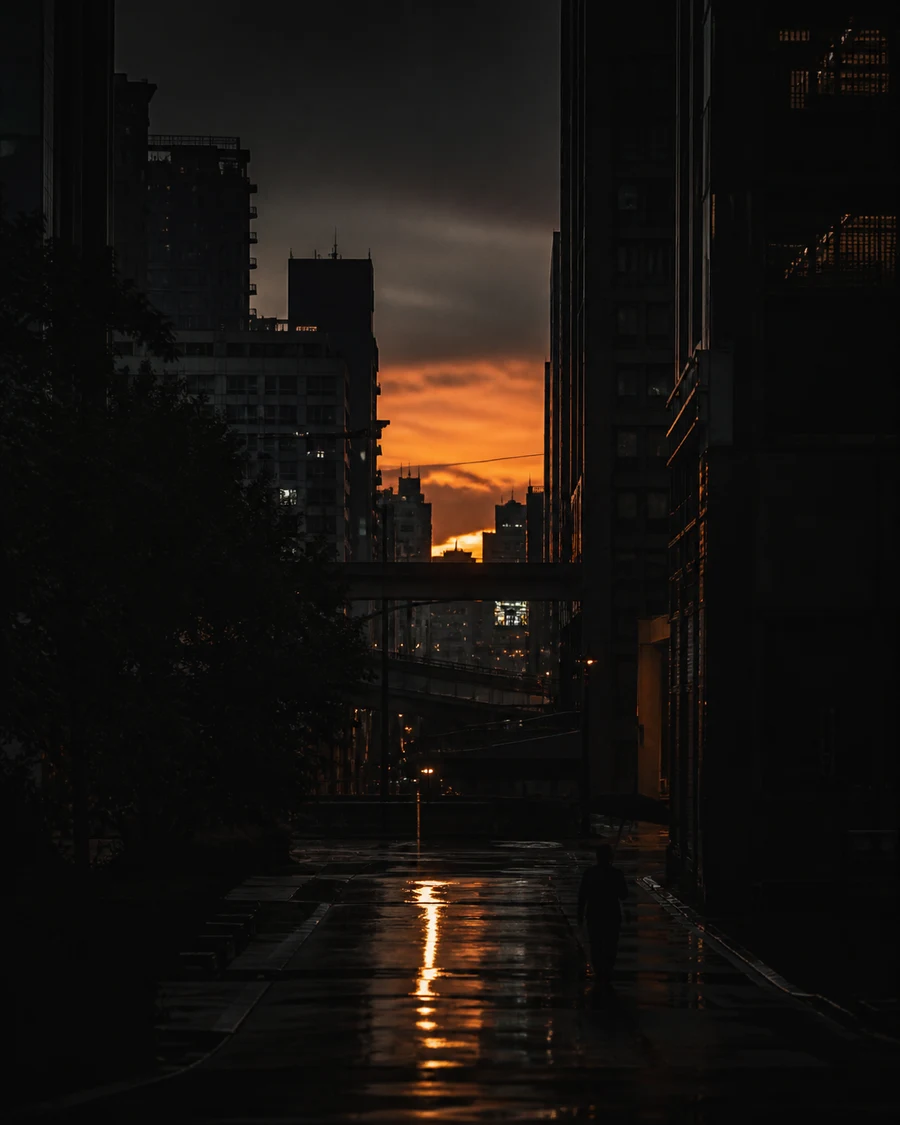 Orange afterglow between Taipei towers reflected on a wet street